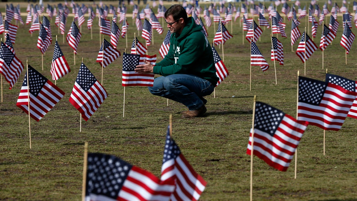  Navy veteran Jeff Hensley of Dallas, Texas, now with Iraq and Afghanistan Veterans of America (IAVA), joins others in placing 1,892 flags representing veteran and service members who have died by suicide to date in 2014, Thursday, March 27, 2014, on the National Mall in Washington. The event also marked the introduction of The Suicide Prevention for America's Veterans Act by Sen. John Walsh, D-Mont., which calls for greater access to mental health care. (Charles Dharapak/AP Photo) 