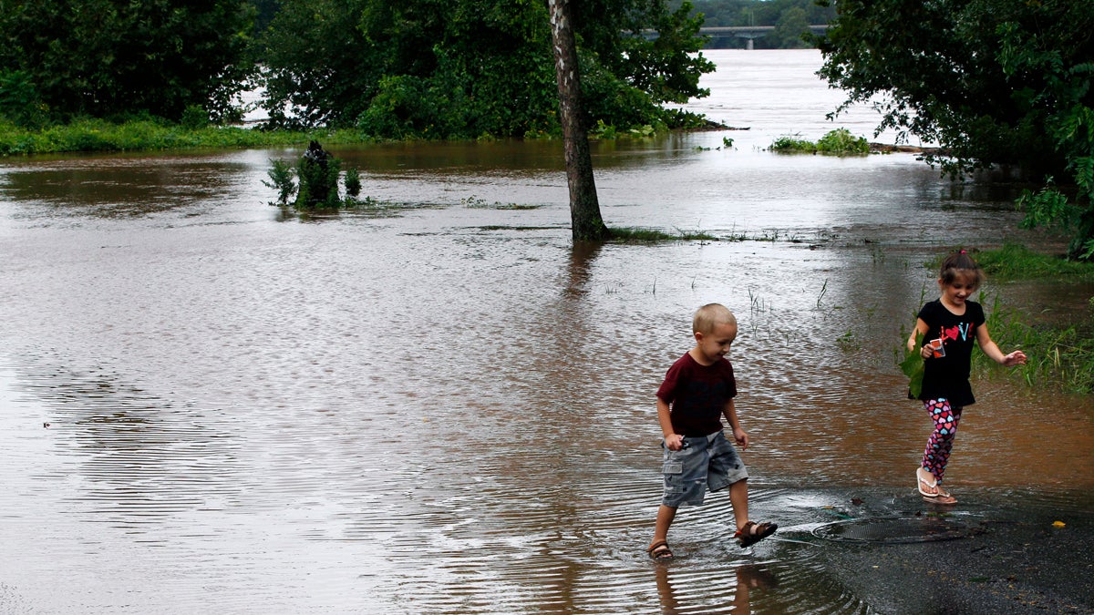  A brother and sister walk in a flooded Delaware Avenue in Yardley, Pa., in August 2011 as the Delaware River overflowed after rains from Hurricane Irene. (Mel Evans/AP Photo) 