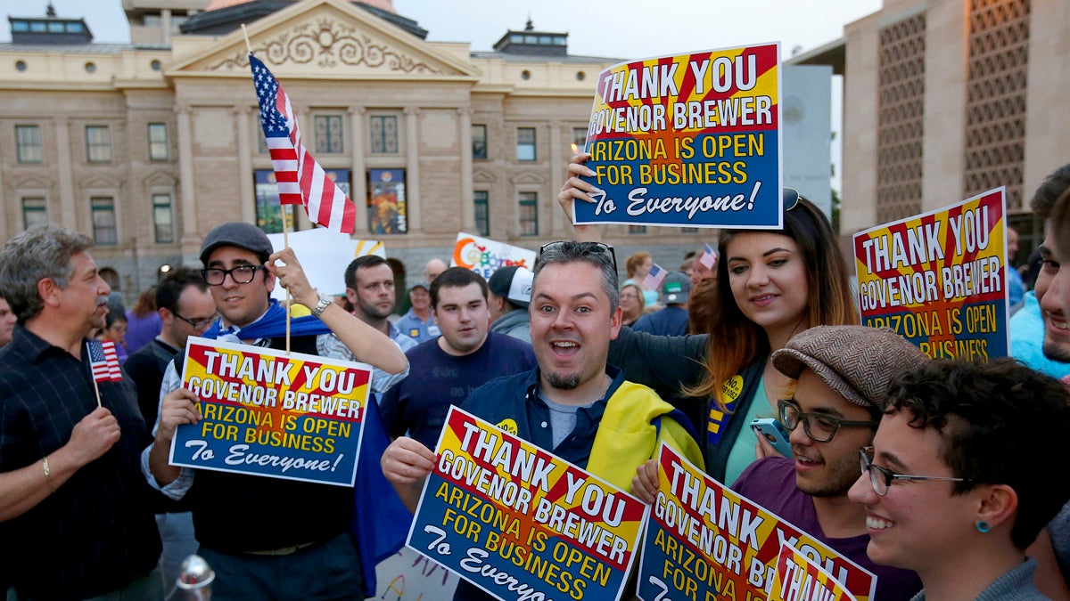  Demonstrators celebrate at the Arizona Capitol on Wednesday after learning that Arizona Gov. Jan Brewer vetoed SB1062, a bill designed to give added protection from lawsuits to people who assert their religious beliefs in refusing service to gays. (AP Photo/Ross D. Franklin) 