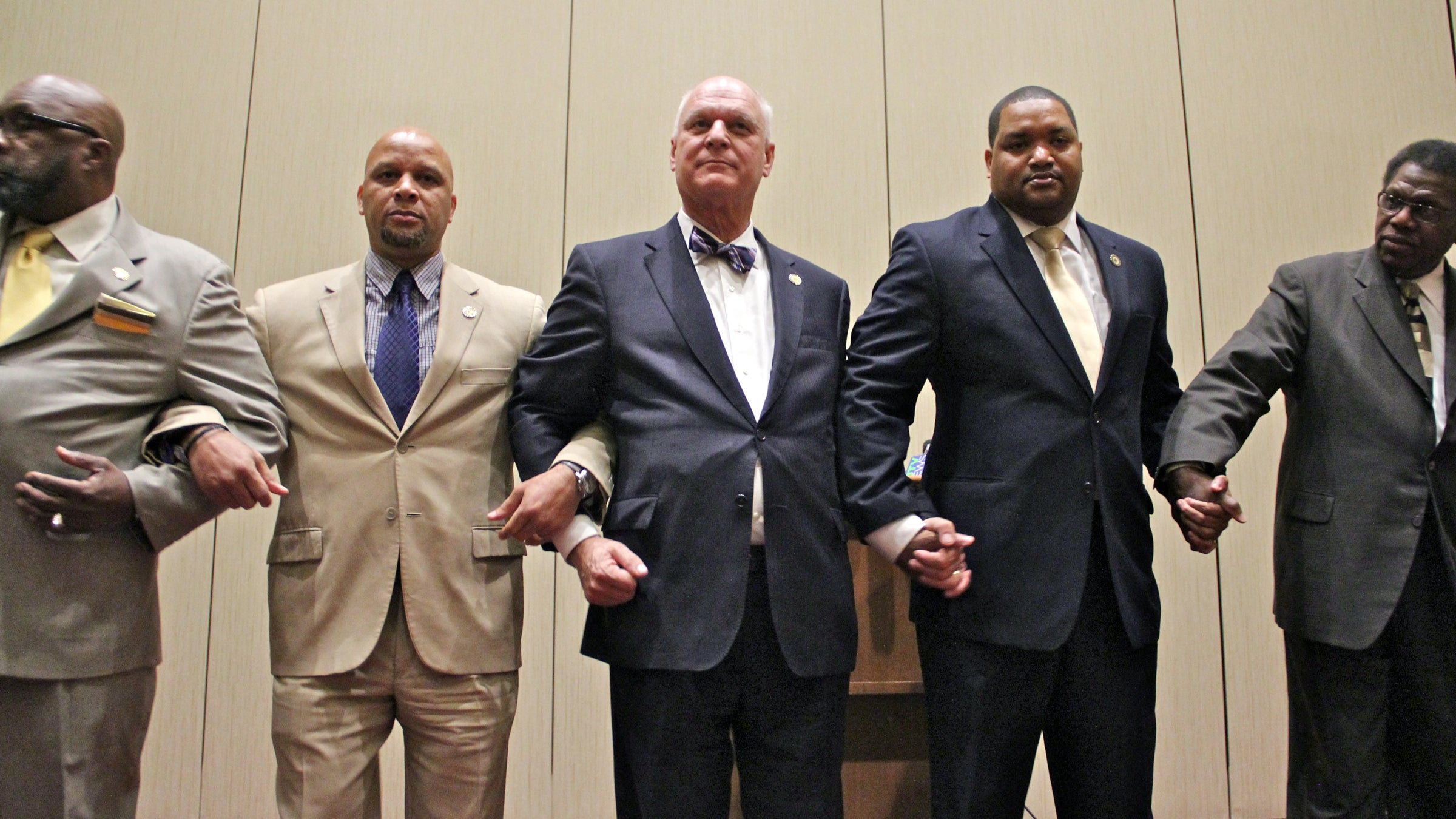 Atlantic City Mayor Don Guardian (center) holds hands with other elected officials as a show of solidarity against a proposed state takeover of the resort city. (Emma Lee/WHYY) 