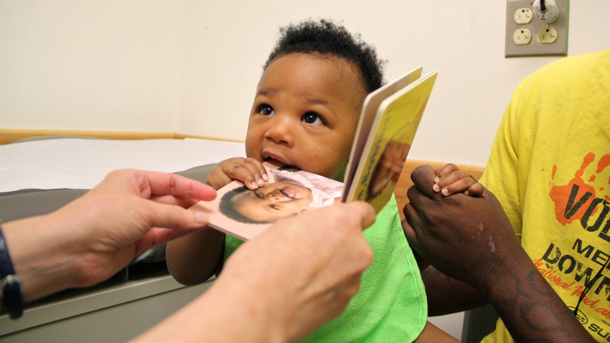  Rahmir Riggins gets a book as part of his six-month checkup at Karabots Pediatric Care Center in West Philadelphia. (Emma Lee/WHYY) 