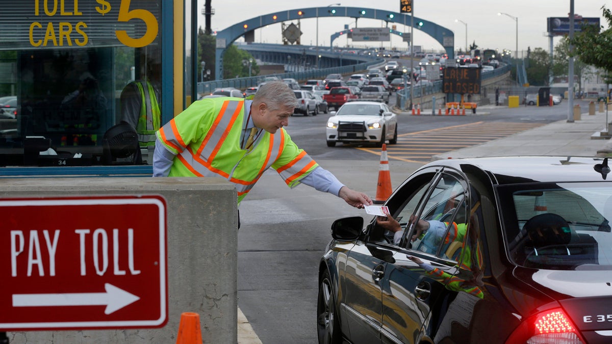  In May, Delaware River Port Authority CEO John Hanson, hands information cards to drivers in Camden at the toll lanes of the Benjamin Franklin Bridge between Camden and Philadelphia. The second phase of the PATCO train track replacement project over the bridge is set to begin this week. (AP Photo, file) 