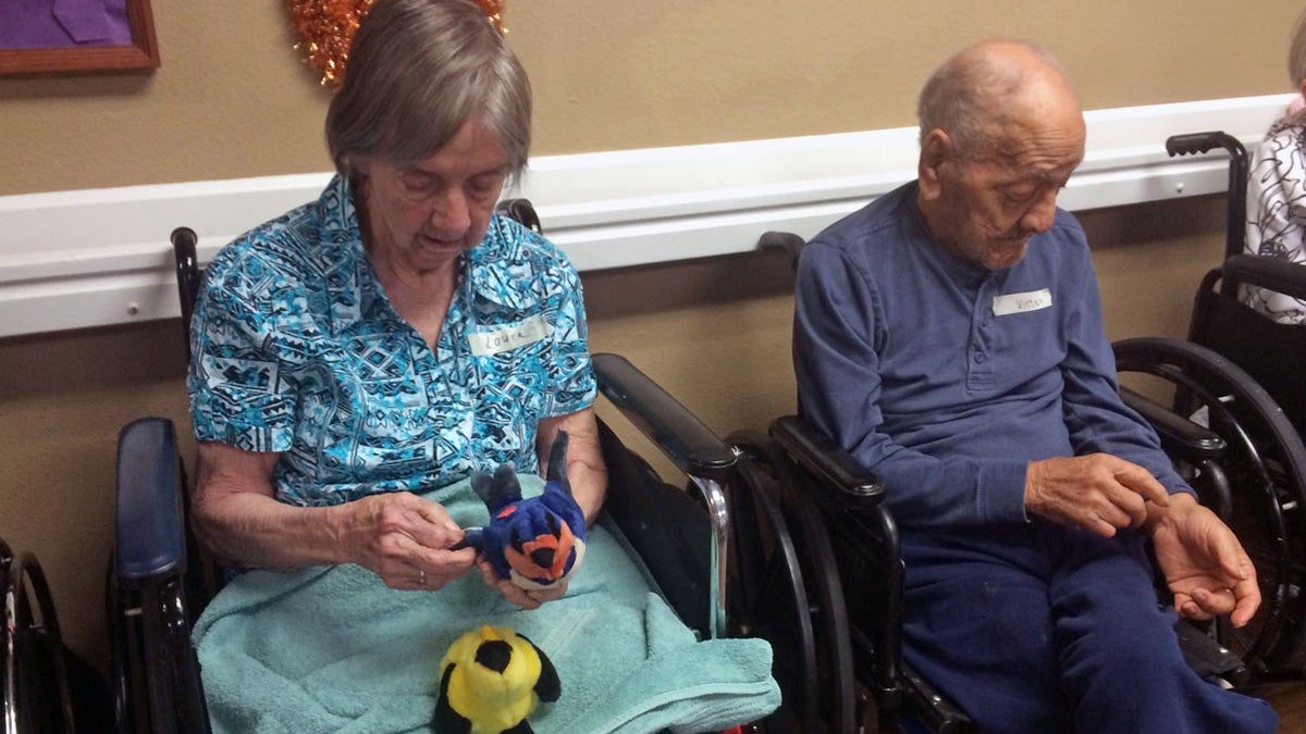 Residents at the Northglenn Heights long term care facility play with plush bird stuffed animals that make real bird calls. (Stephanie Paige Ogburn/for WHYY)