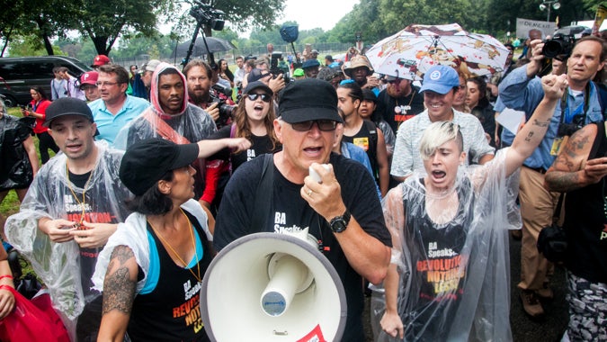 Members of the communist group Revolution Nothing Less march through FDR Park Thursday. (Brad Larrison for NewsWorks)