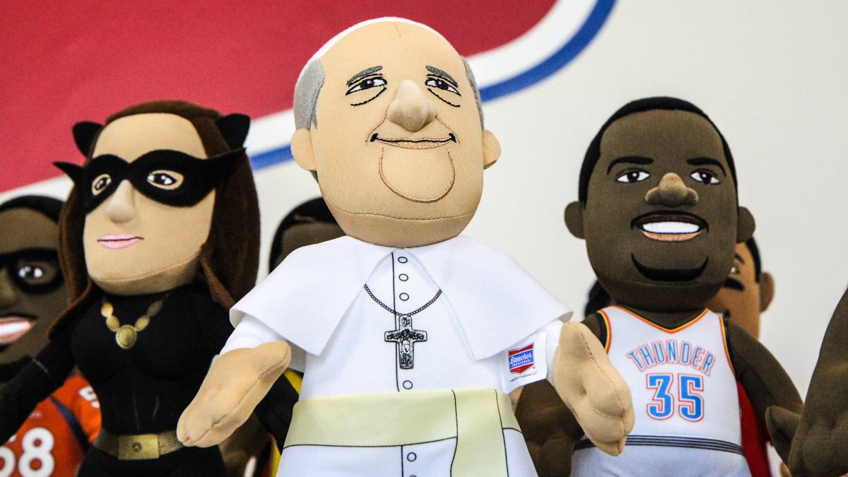A Pope Francis Bleacher Creature stands among the ranks of other plush toys. (Kimberly Painter/WHYY)
