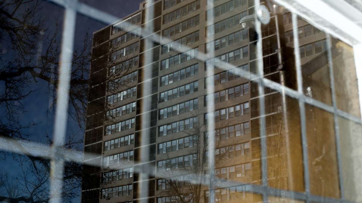 The soon-to-be-demolished Queen Lane Apartments, as seen reflected in a window of Mt. Moriah Baptist Church, which sits across Pulaski Avenue from the site. (Bas Slabbers/for NewsWorks) 