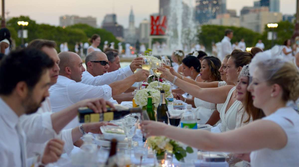 A toast is made as the sun sets over Center City during Philadelphia's fifth Dîner en Blanc.