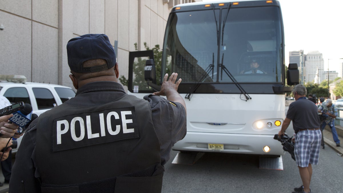  Officer Chester Hampton, inspector for the Philadelphia Police Department truck enforcement division, instructs the bus driver during an inspection. (Charlie Kaier/for NewsWorks) 