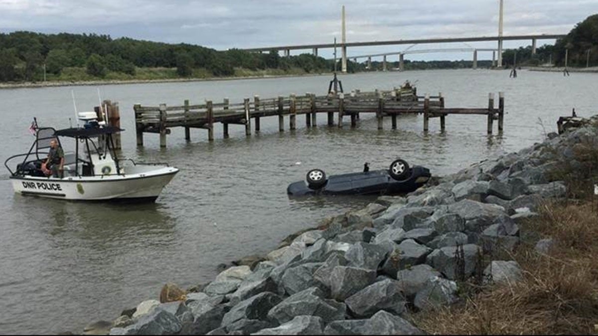  (Overturned vehicle in C & D Canal results in charges of reckless driving and damaging state property against Dover man /DNREC Fish & Wildlife Natural Resources Police Photo)  