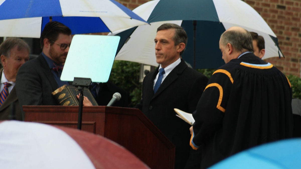 Governor John Carney takes the oath of office from Delaware Chief Justice Leo Strine on a rainy morning outside Legislative Hall in Dover. (Mark Eichmann/WHYY)