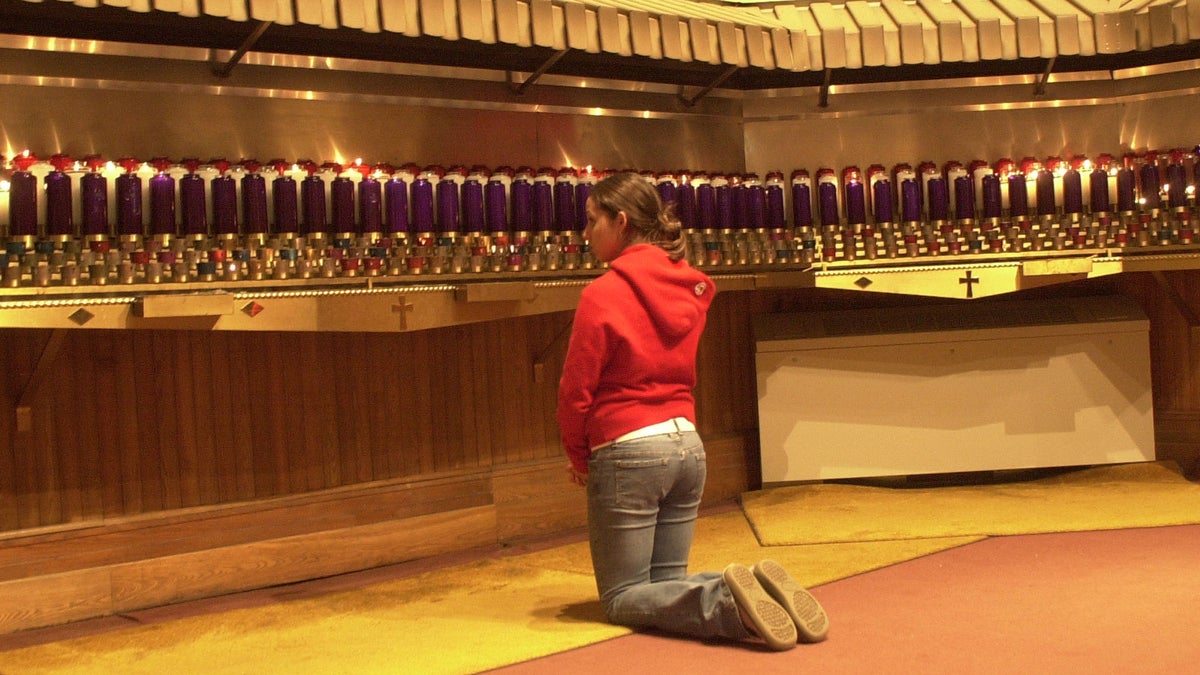  A young catholic is shown saying a Novena prayer. (AP Photo/Adrian Keating, file) 