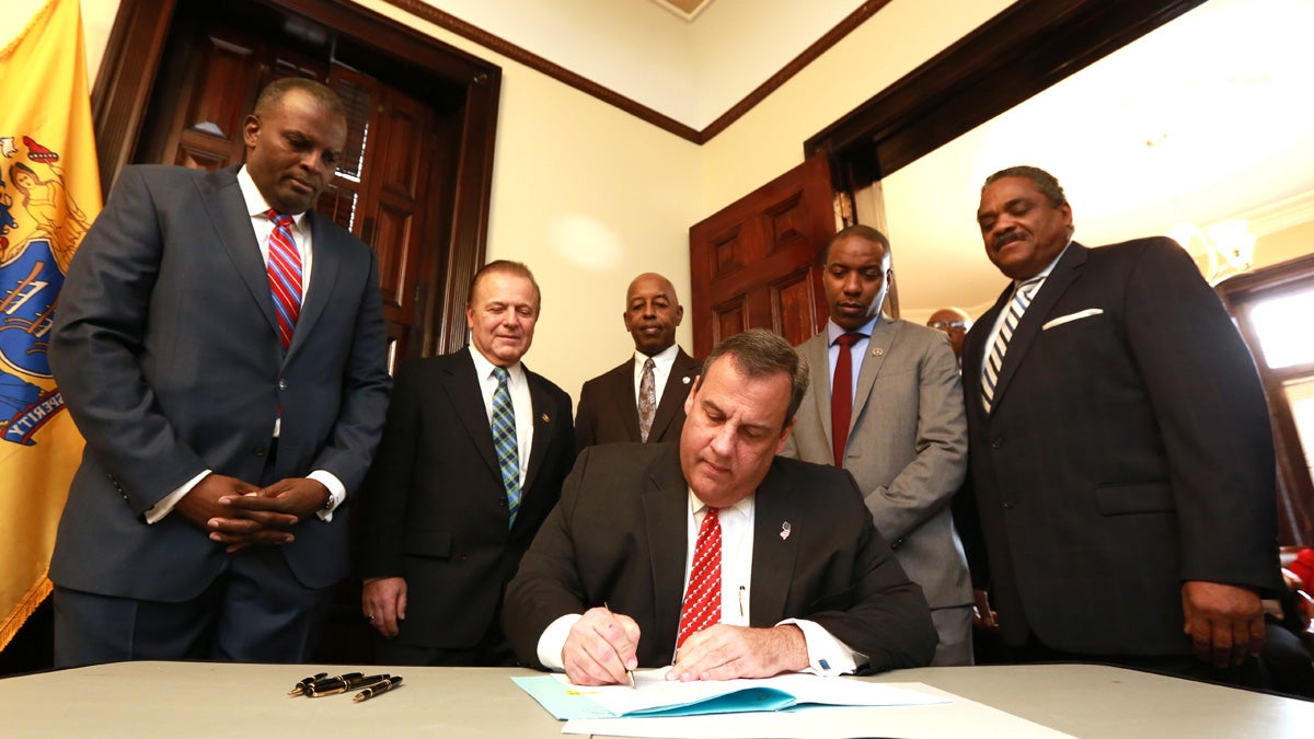 Gov. Chris  Christie signs the legislation at the Trenton offices of  the African American Chamber of Commerce of New Jersey. (Governor's office/Tim Larsen)