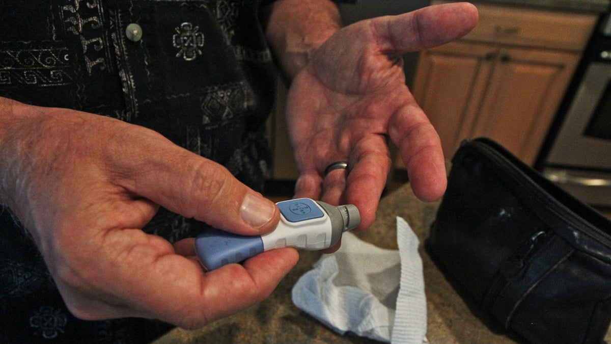 Randy Childress pricks his finger several times a day to monitor his blood sugar. (Kimberly Paynter/WHYY)