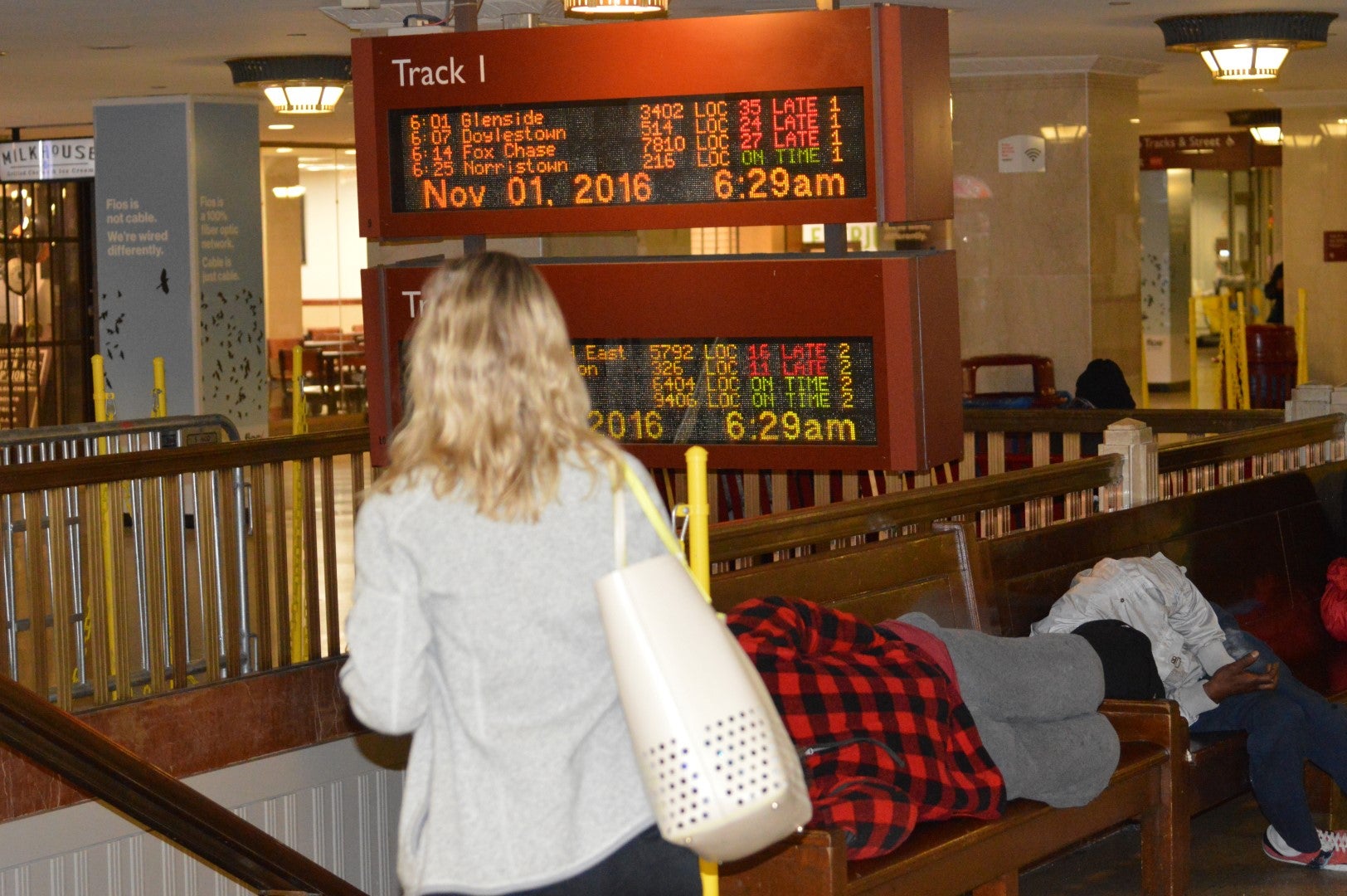 A commuter looks at notices of delays on screen at Suburban Station. (Tom MacDonald/WHYY)