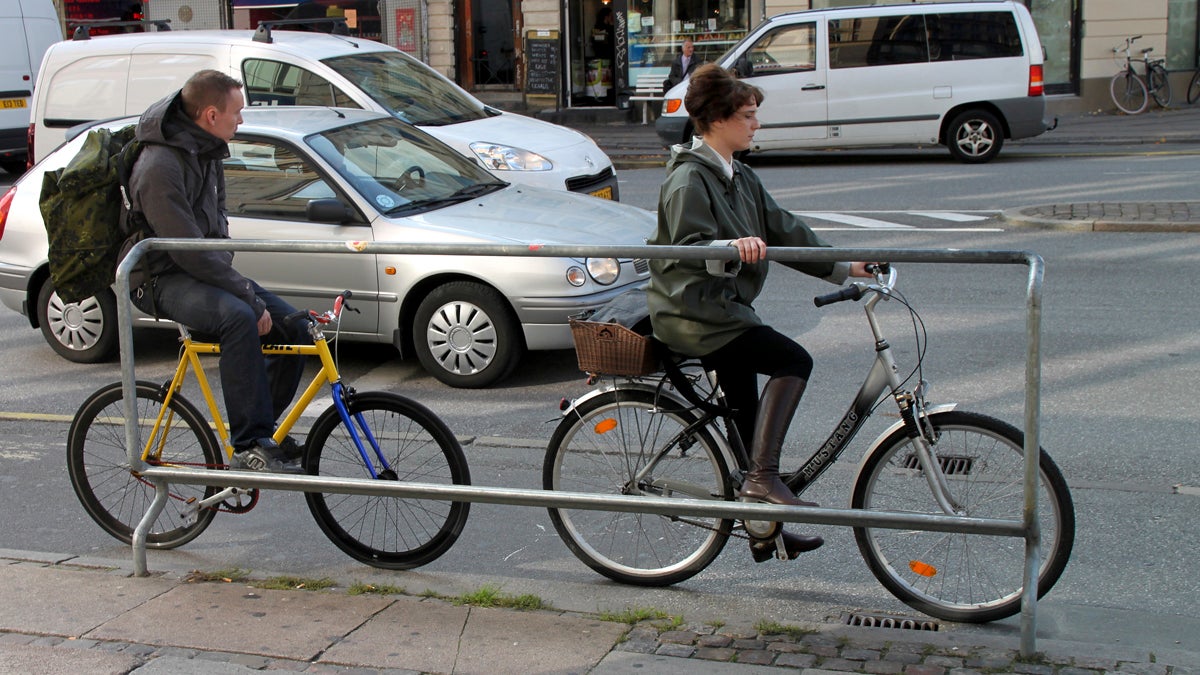 Two cyclists use a foot rest with handles at a major intersection on a downtown Copenhagen street with bicycle-friendly features. (AP Photo/Jan M. Olsen) 