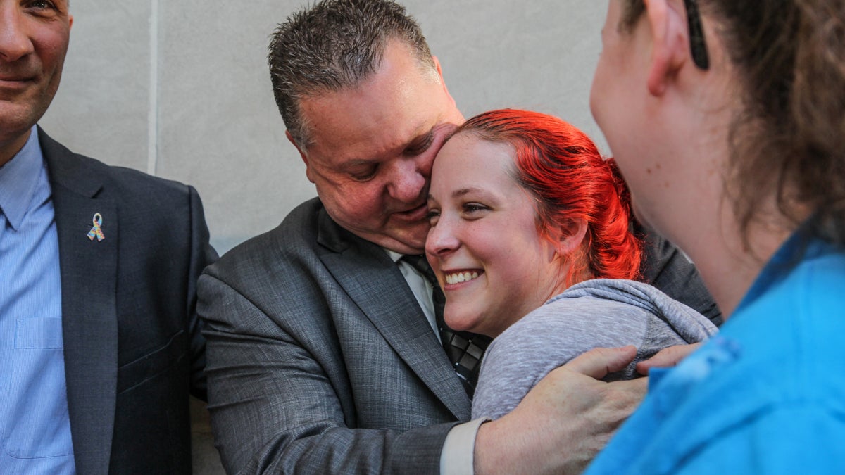 Officer Perry Betts hugs his daughter  Samantha after the not guilty verdict is delivered. (Kimberly Paynter/WHYY)