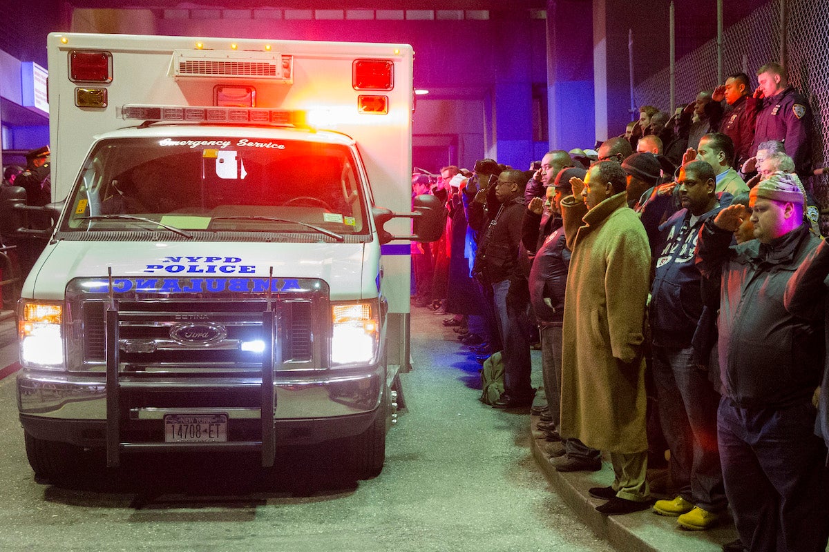  Mourners stand at attention as the bodies of two fallen NYPD police officers are transported from Woodhull Medical Center in New York. / AP Photo 