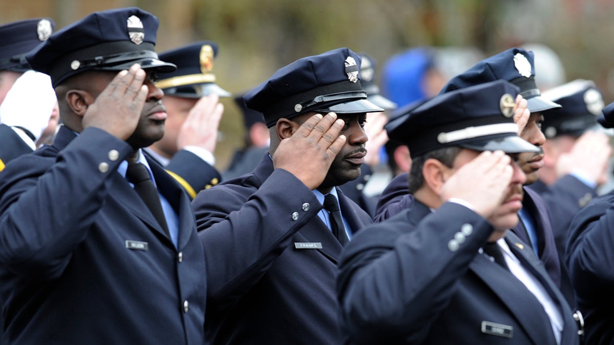 Firefighters salute the casket of Lieutenant Joyce Craig as it is lifted onto an Engine Company 64 fire truck.