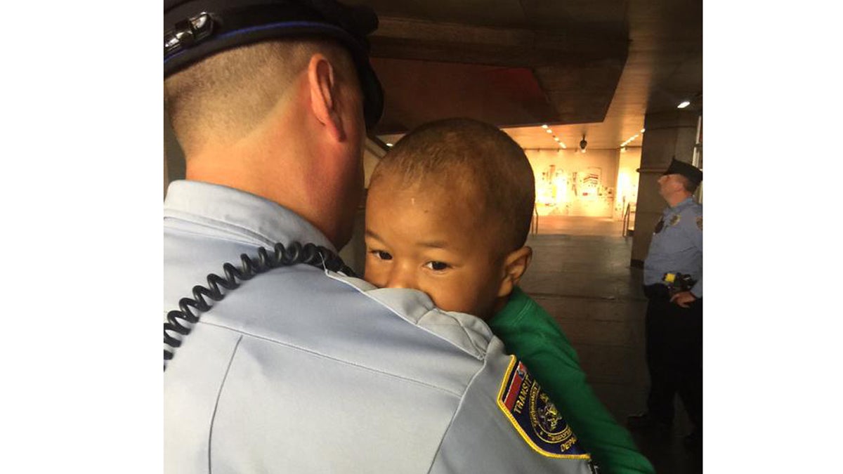  A SEPTA officer carries the child found wandering in LOVE Park Friday night. (Photo/Bill Newbold)  