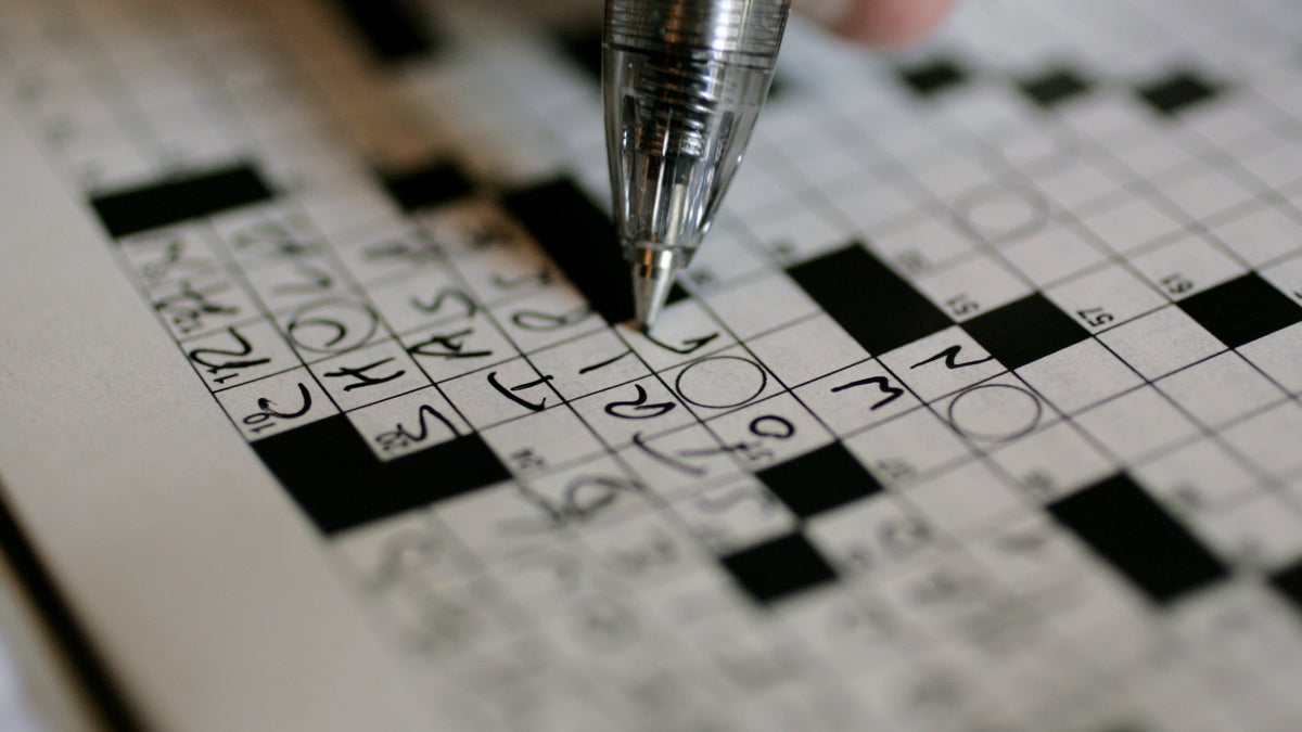 A puzzle fan is shown working on the New York Times crossword puzzle. (AP Photo/Carolyn Kaster