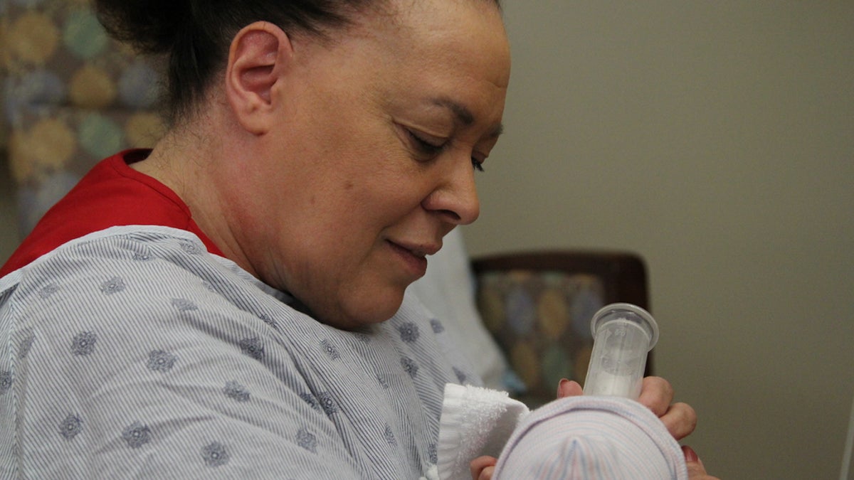 Beverly Thornton holds a baby at Magee Women’s Hospital in Pittsburgh. (Sarah Schneider/for WHYY)