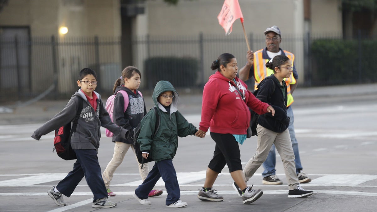  School children use a cross walk while heading to Sam Tasby Middle School in the Vickery Meadow section of Dallas, Tuesday, Oct. 21, 2014. Dallas school officials say four of the five students in their district who were being monitored for Ebola have returned to school after being cleared by health authorities. (AP Photo/LM Otero) 