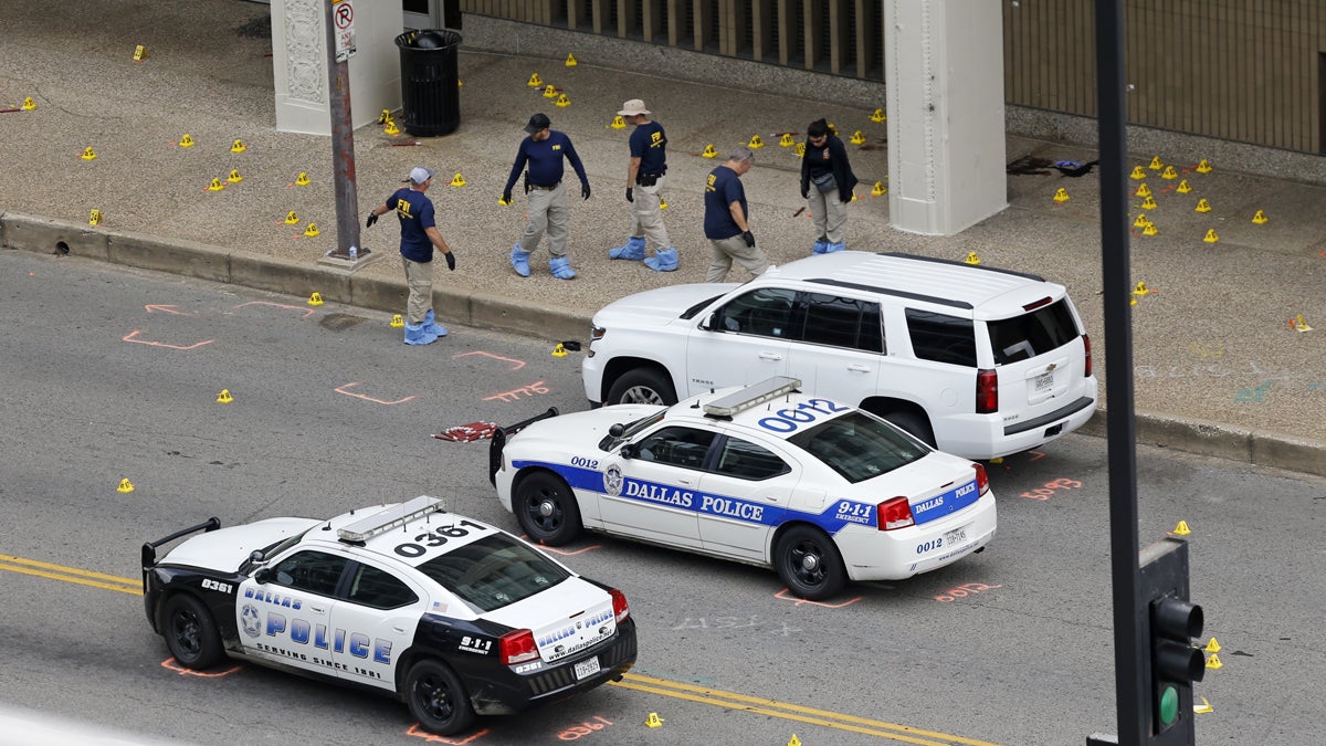 An FBI evidence response team is shown on Saturday investigating the scene of a sniper attack on Dallas police officers. (AP Photo/Gerald Herbert)