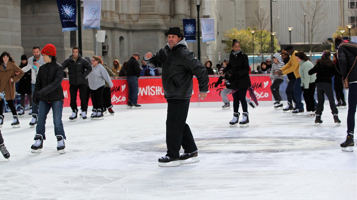 A skater dressed as Rocky Balboa cuts a figure in the center of the ice. (Emma Lee/WHYY)