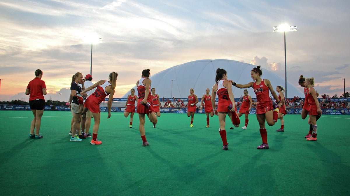 Olympic field hockey players stretch on the turf field at Spooky Nook in Manheim, Pennsylvania. A domed field and indoor training center allow practice year-round. (Emma Lee/WHYY)