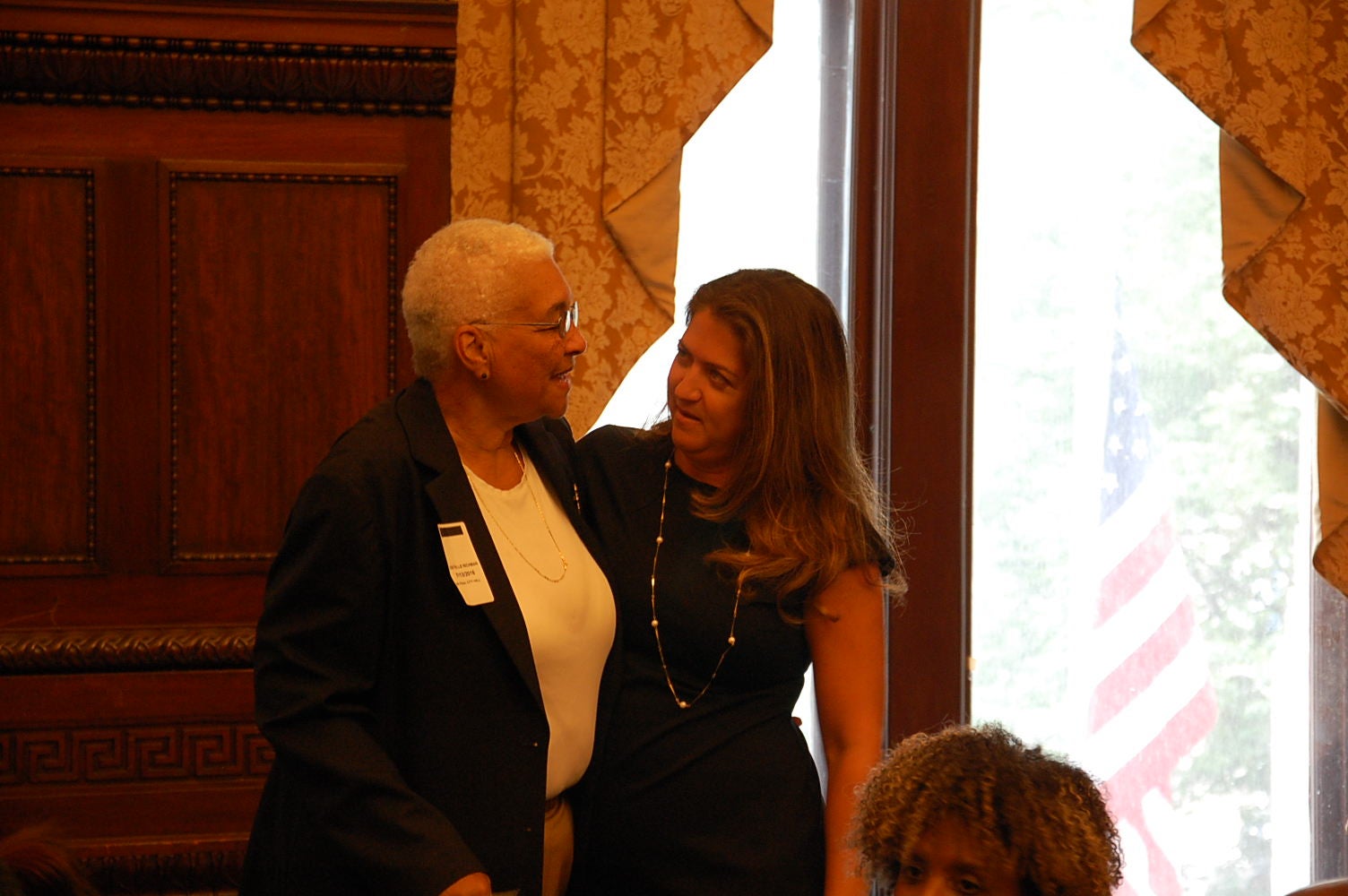 Incoming DHS Commissioner Cynthia Figueroa (right)greets Estelle Richman