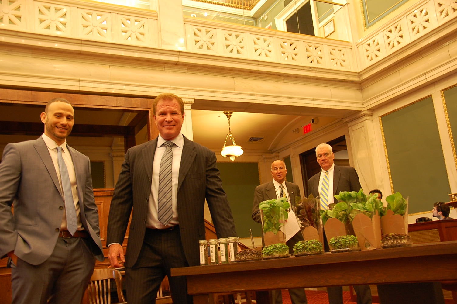 Farmers Leon Weingrad and Jack Griffin stand next to a sample of their vertical crops. (Tom MacDonald/WHYY)