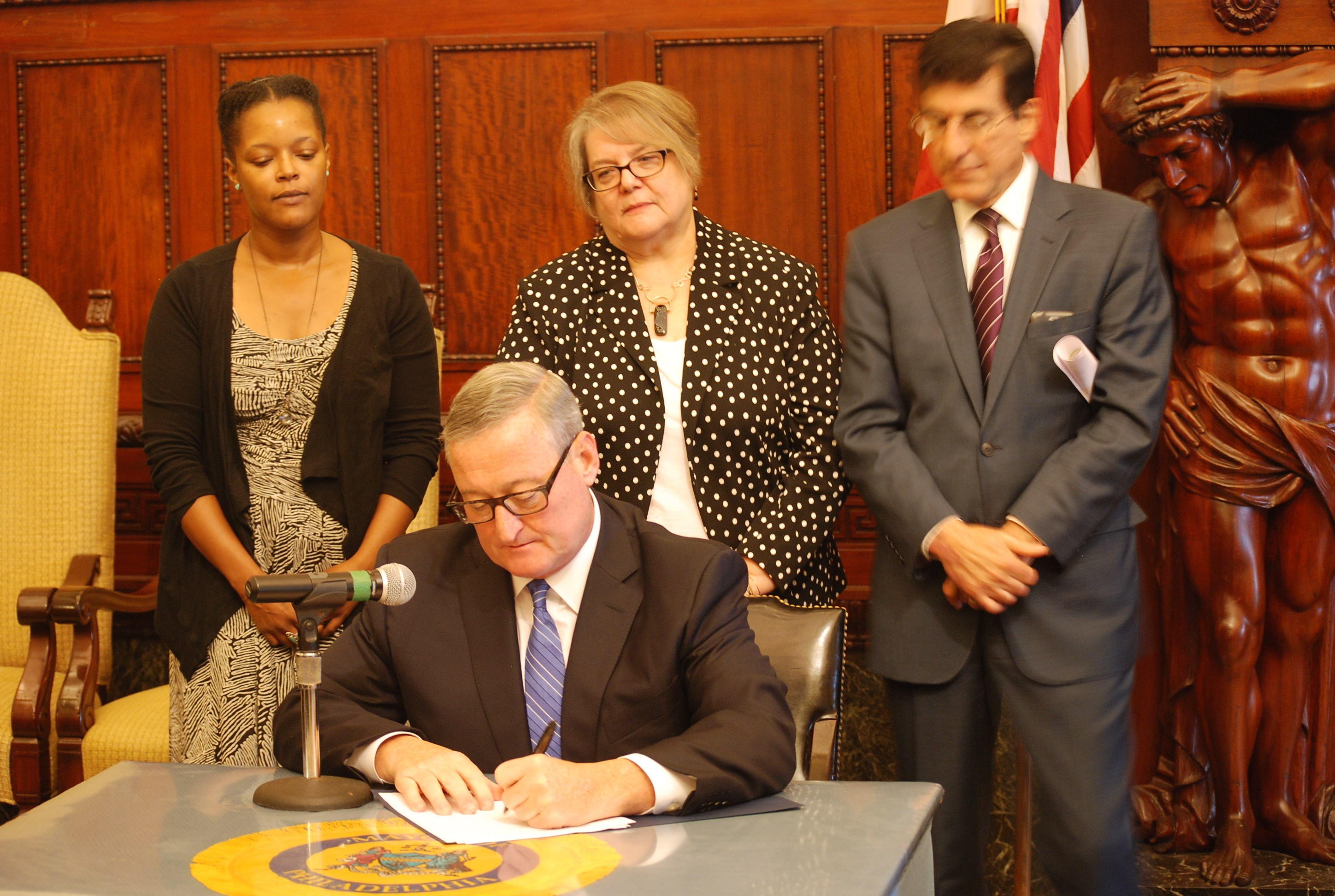 Mayor Jim Kenney signs an executive order rebranding the  Mayor's Commission on Literacy as the Office on Adult Education.(Tom MacDonald/WHYY)