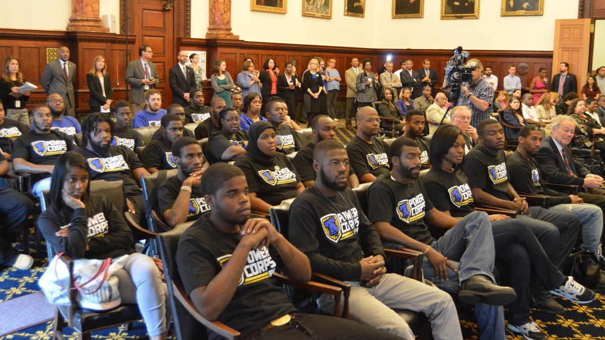  Power Corps members listen to the announcement of federal funding of $1 million to help continue anti-violence efforts in Philadelphia. (Tom MacDonald/WHYY) 