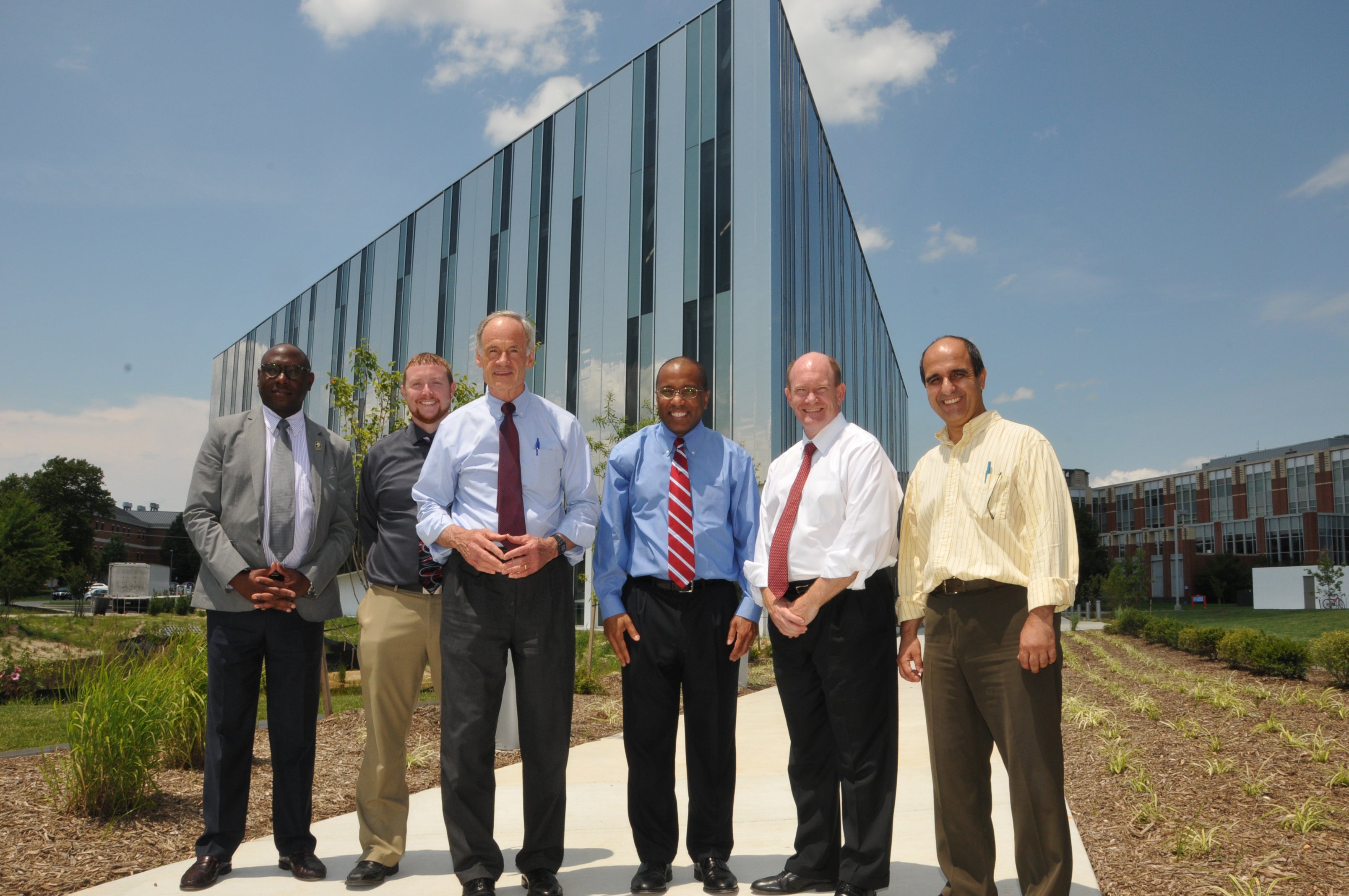  Senators Tom Carper (third from left) and Chris Coons (second from right) pose with Delaware State president Harry Williams (center) outside the university's new optics facility. (Photo courtesy of Delaware State University) 