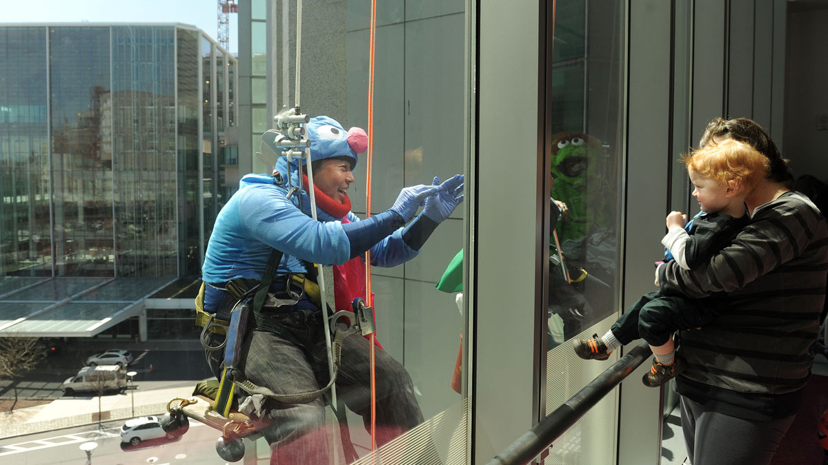  A window washer from Jenkintown Building Services repels down the South Tower at CHOP as Grover to help celebrate Earth Day.  (Peter Tobia/ For NewsWorks) 