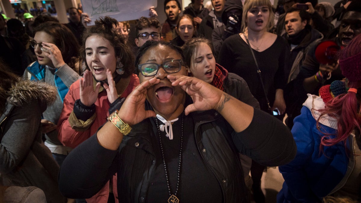 Protestors chant slogans inside the terminal at Philadelphia International Airport. (Branden Eastwood for NewsWorks)