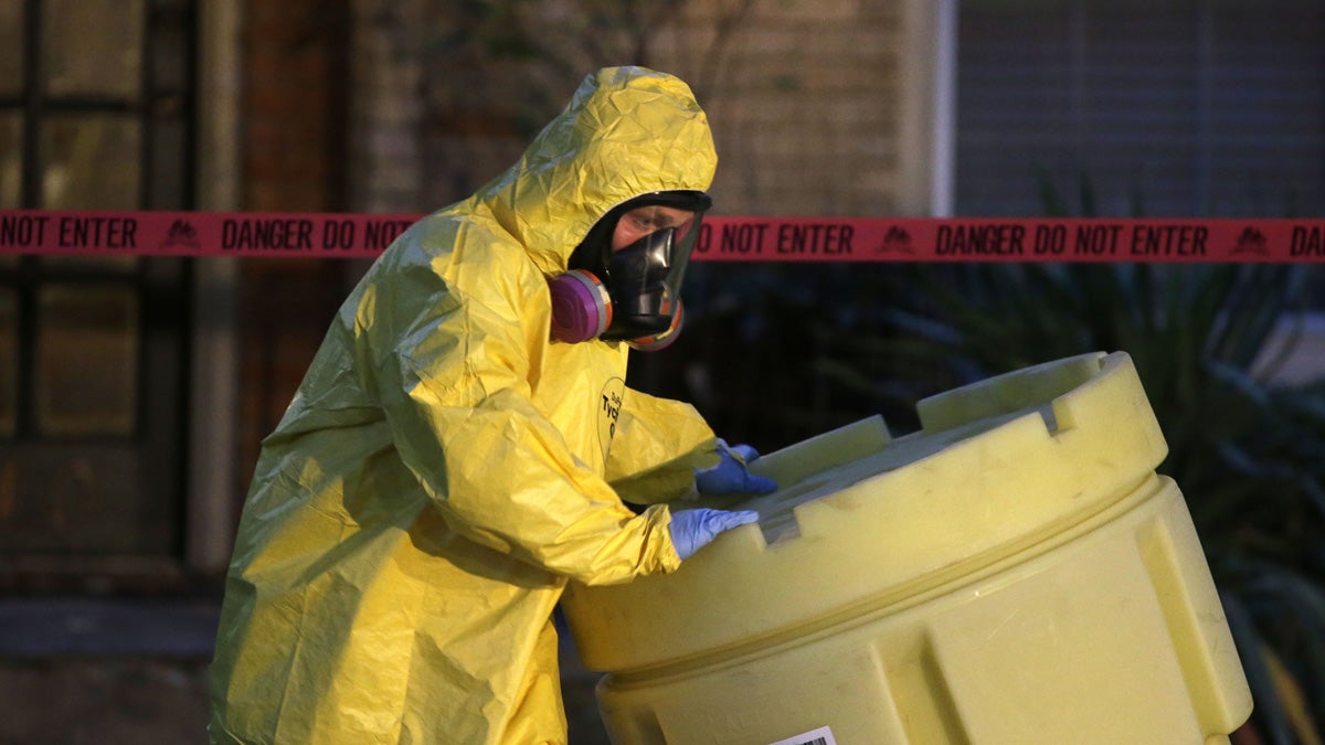 A hazmat worker moves a barrel while finishing up cleaning outside the apartment of a hospital worker who tested positive for ebola in Dallas.  (AP Photo/LM Otero)