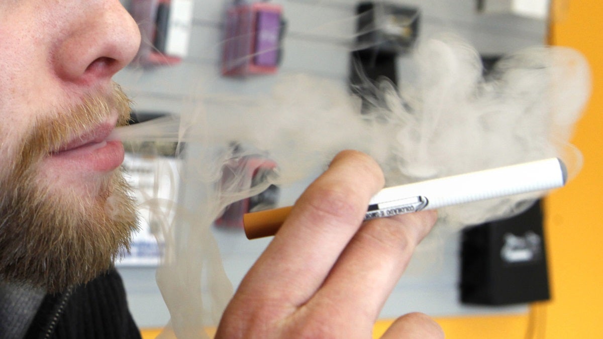  A sales associate demonstrates the use of a electronic cigarette. (AP Photo/Ed Andrieski) 