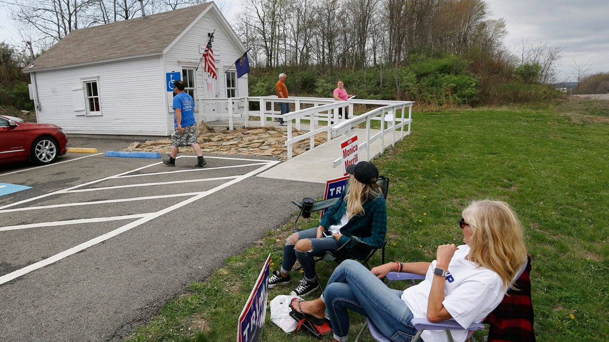  A few campaign workers sit outside the small polling location called the Simpson Voting House in New Alexandria, Pa. (AP Photo/Keith Srakocic) 