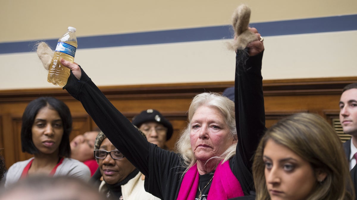  Glaydes Williamson of Flint, Mich., holds up a bottle of Flint water and handfuls of hair on during testimony at the House Oversight and Government Reform Committee hearing on Feb. 3 to examine the ongoing situation. (AP Photo/Molly Riley) 