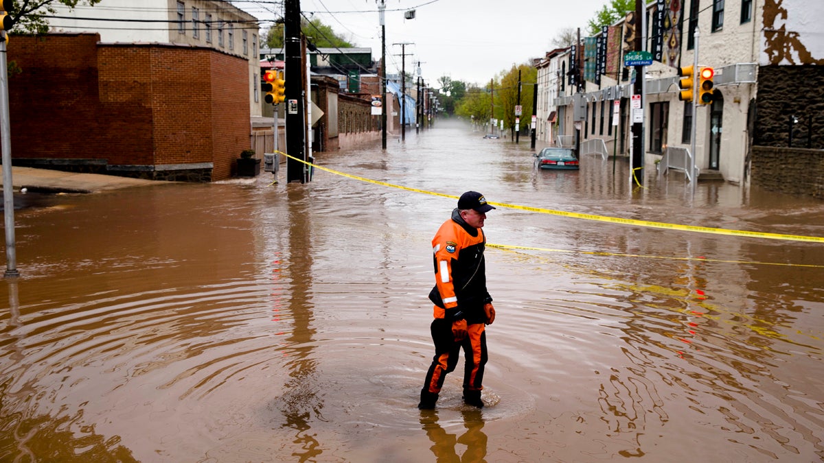 Marine unit police officer Robert Jonah walks through flood waters from the Schuylkill River on Main Street in the Manayunk neighborhood of Philadelphia on May 1