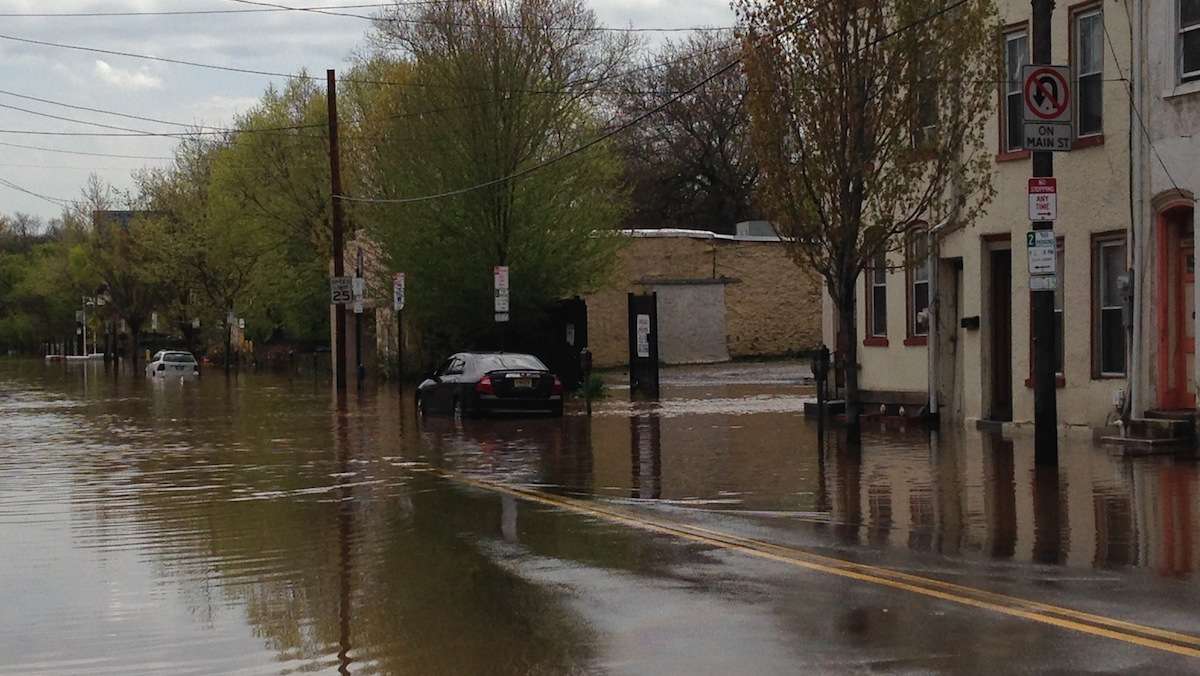  A view of a flooded Main Street on Thursday afternoon. The road was open by Friday, but the job of cleaning up remained. (Neema Roshania/WHYY) 