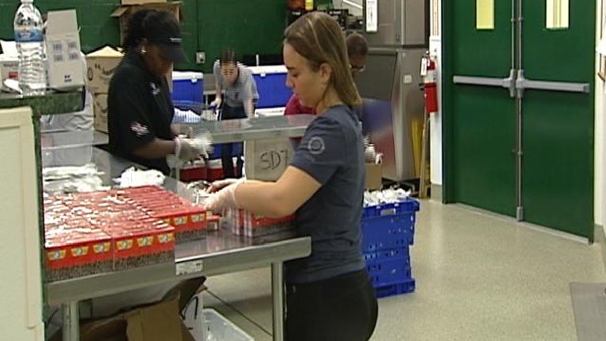  Volunteers pack food into coolers at the Food Bank in Newark. (Charlie O'Neill/WHYY) 