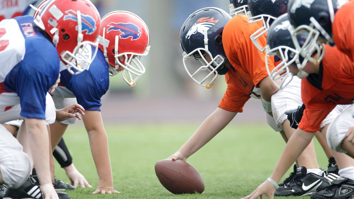 Players line up in three-point stances during a 6th grade youth football game in Richardson