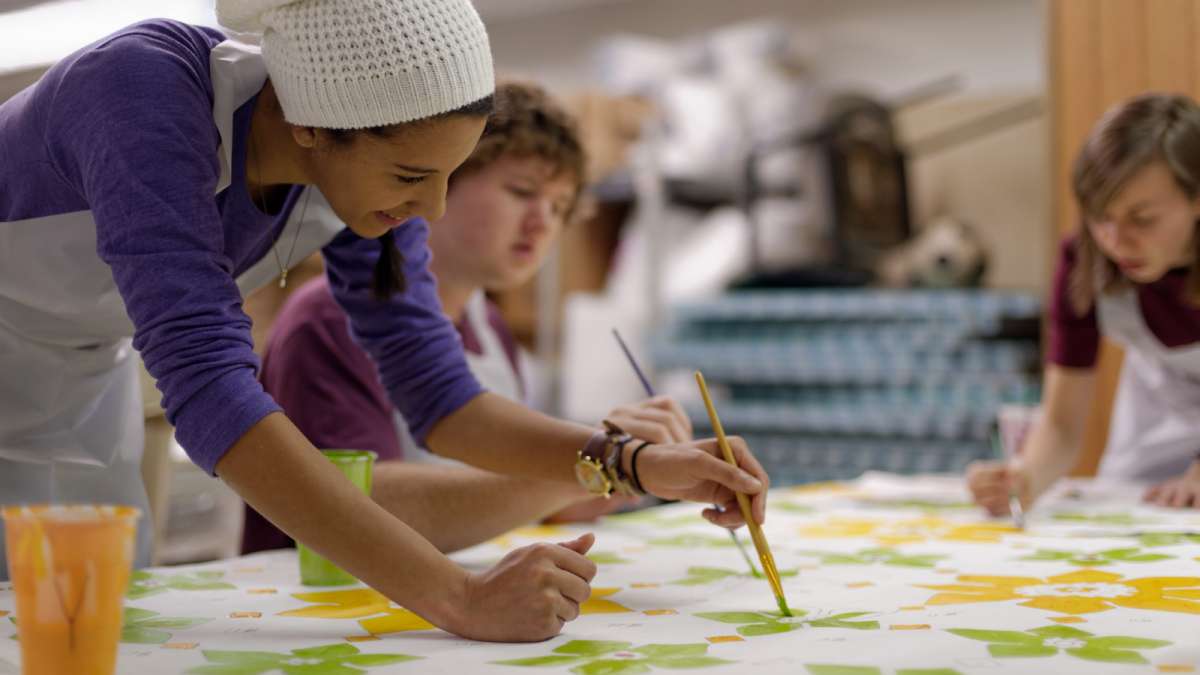 Community members help fill in the decorative elements of what will become the 'Windows of Peace' part of the mural. (Bastiaan Slabbers/for NewsWorks)