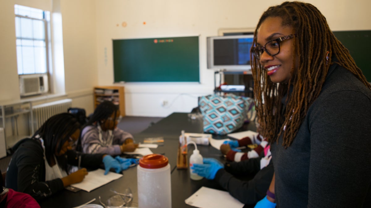 Antoinette Thwaites helps a group of kids work through a science experiment in an after school program. (Paige Pfleger/WHYY)