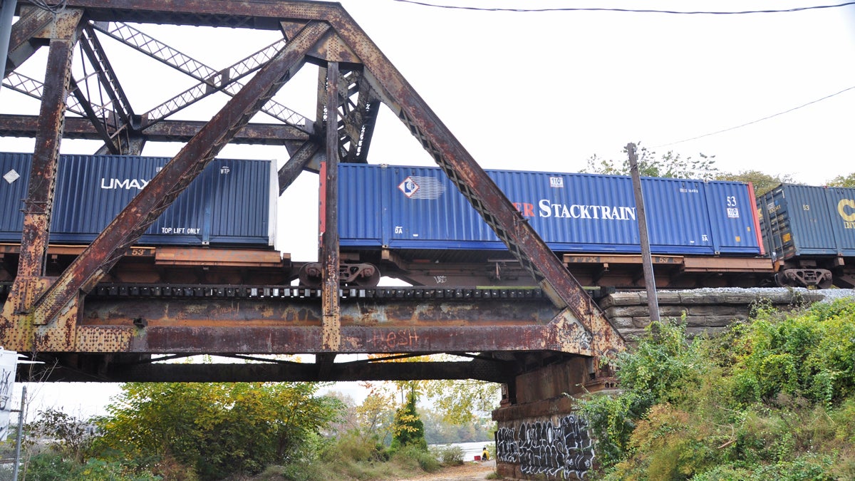  A freight train crosses a bridge in south Philadelphia.  (PlanPhilly file image) 