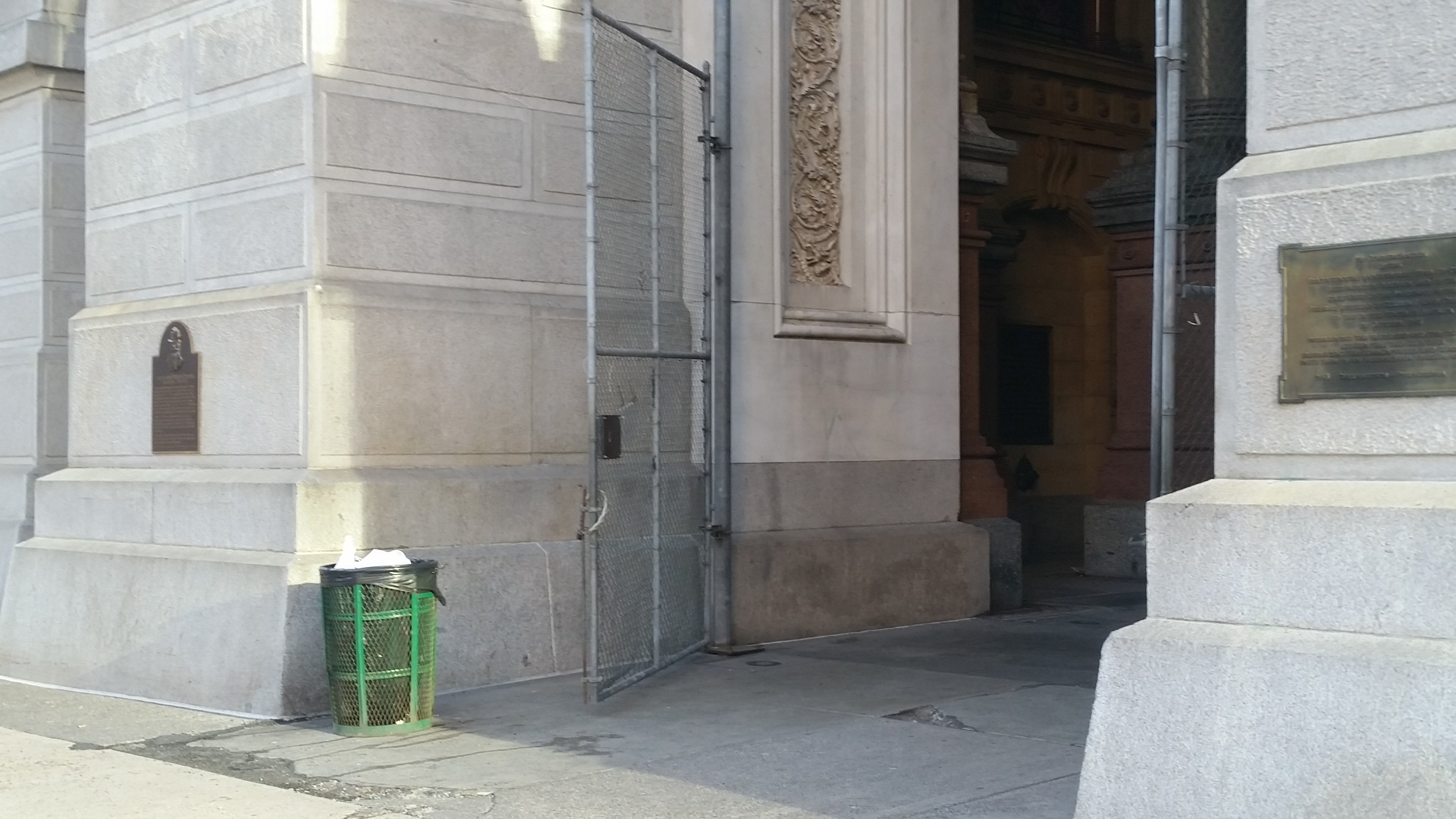  A cyclone fence closes one of the entrances to Philadelphia's City Hall. The four entrances soon will be graced with replicas of the gates designed by architect John McArthur. (Tom MacDonald/WHYY) 