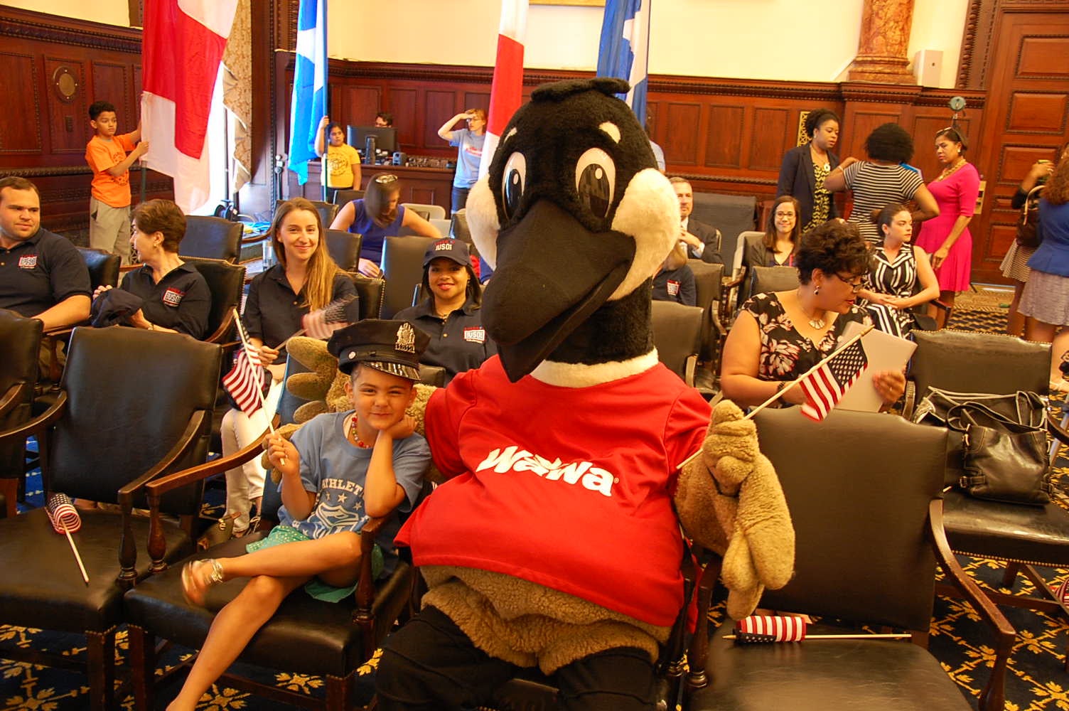 Wawa's mascot and a friend listen to the announcement of Welcome America activities.(Tom MacDonald/WHYY)