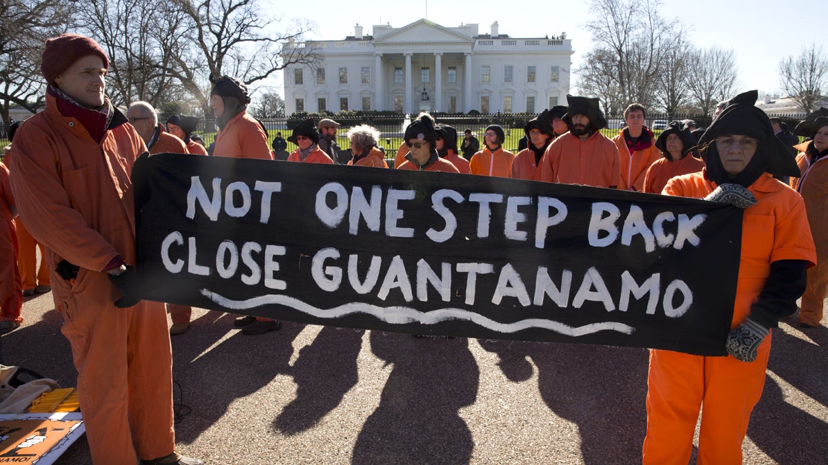 Protesters wearing orange jumpsuits